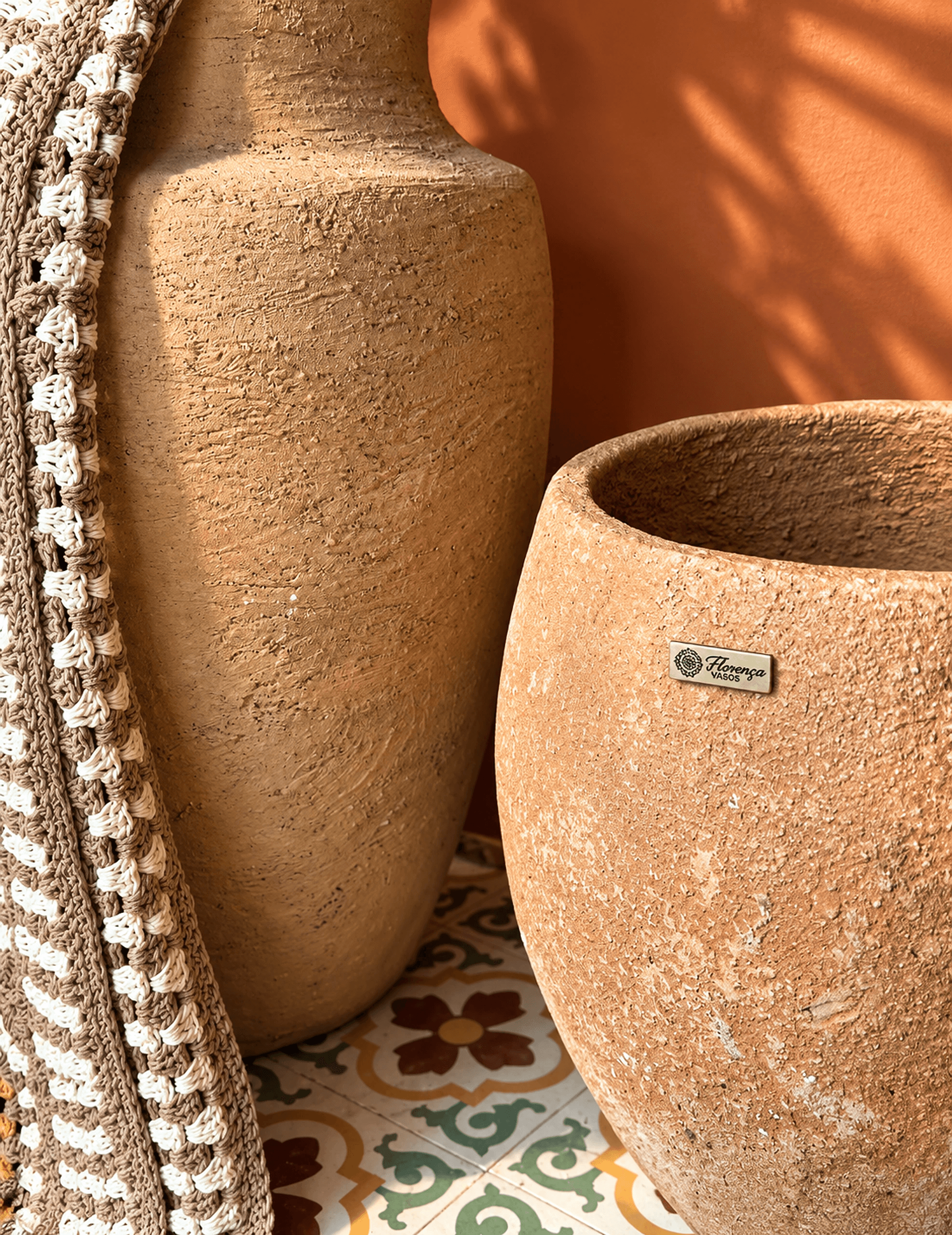 Dois vasos Florença em tom terracota claro ao sol, sobre ladrilho hidráulico